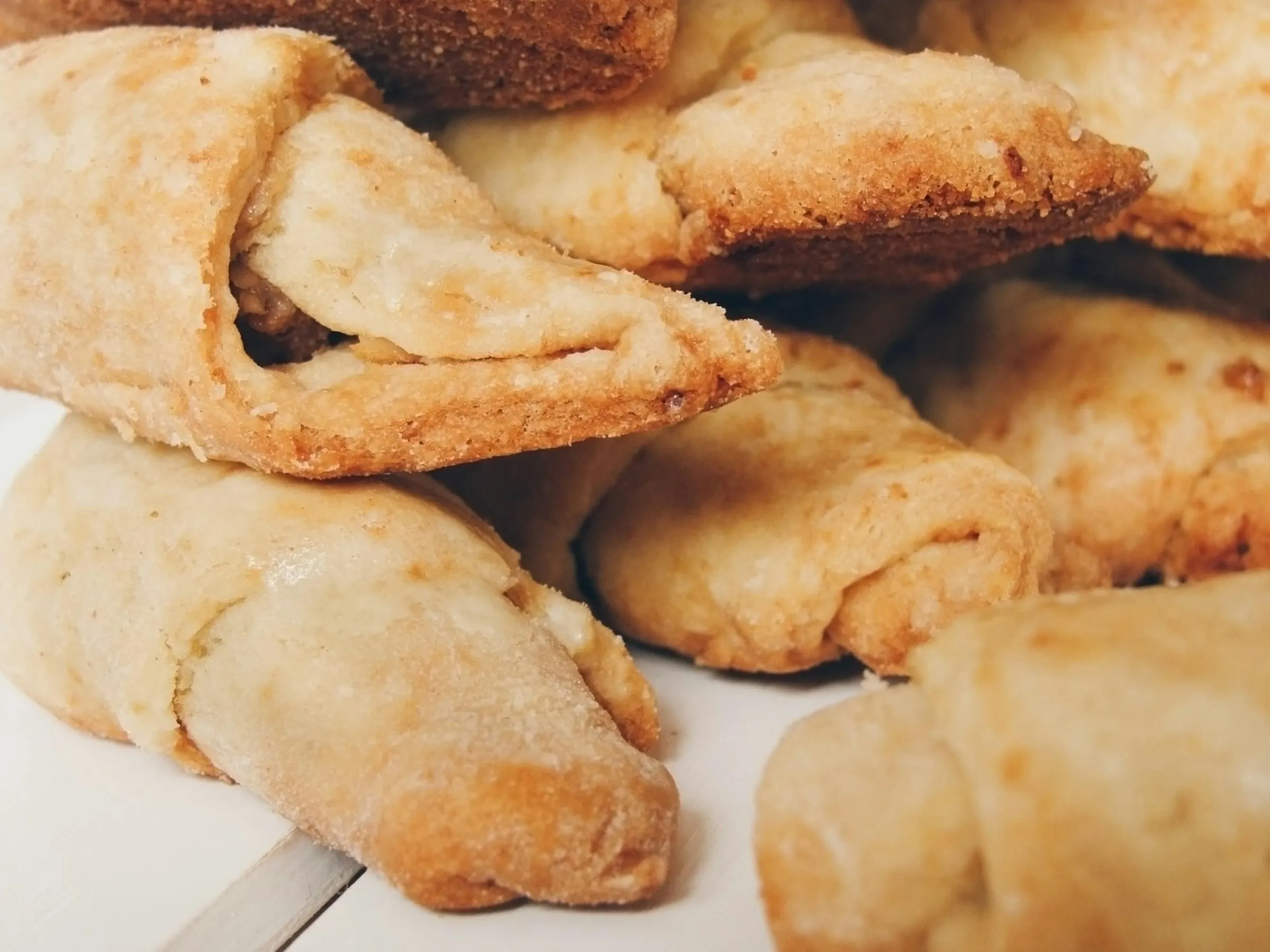 A pile of golden rolled crescent pastries (stock photo)
