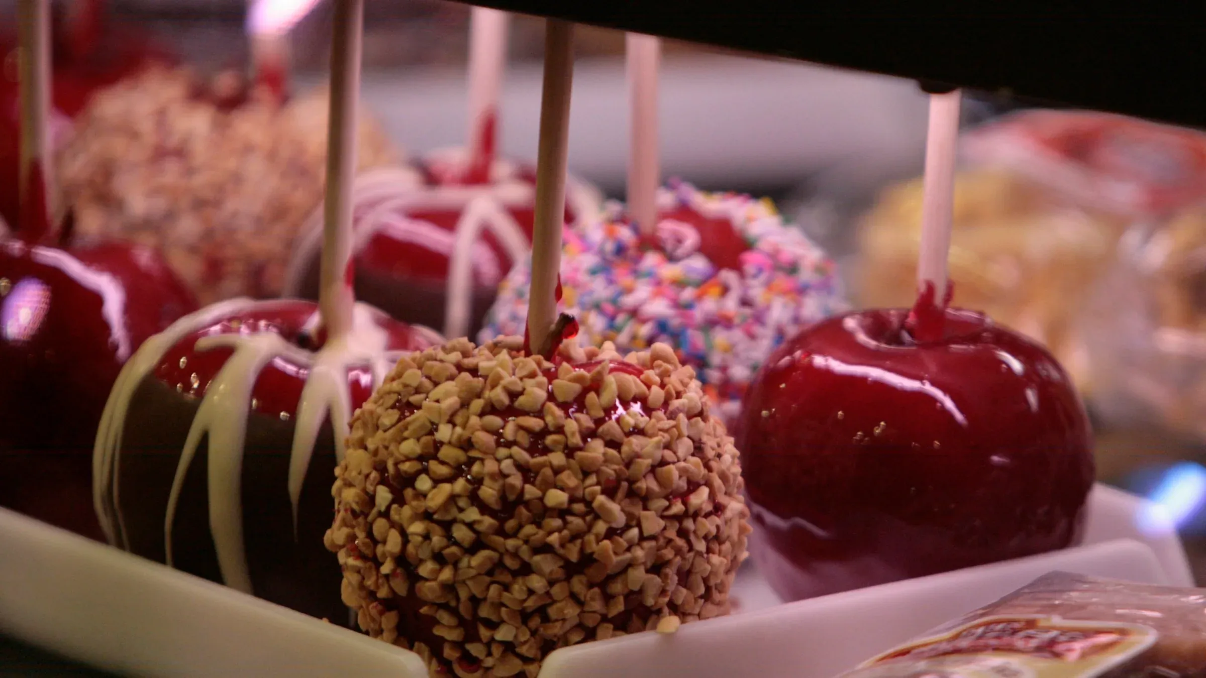Caramel, candy and sprinkle-coated apples on sticks