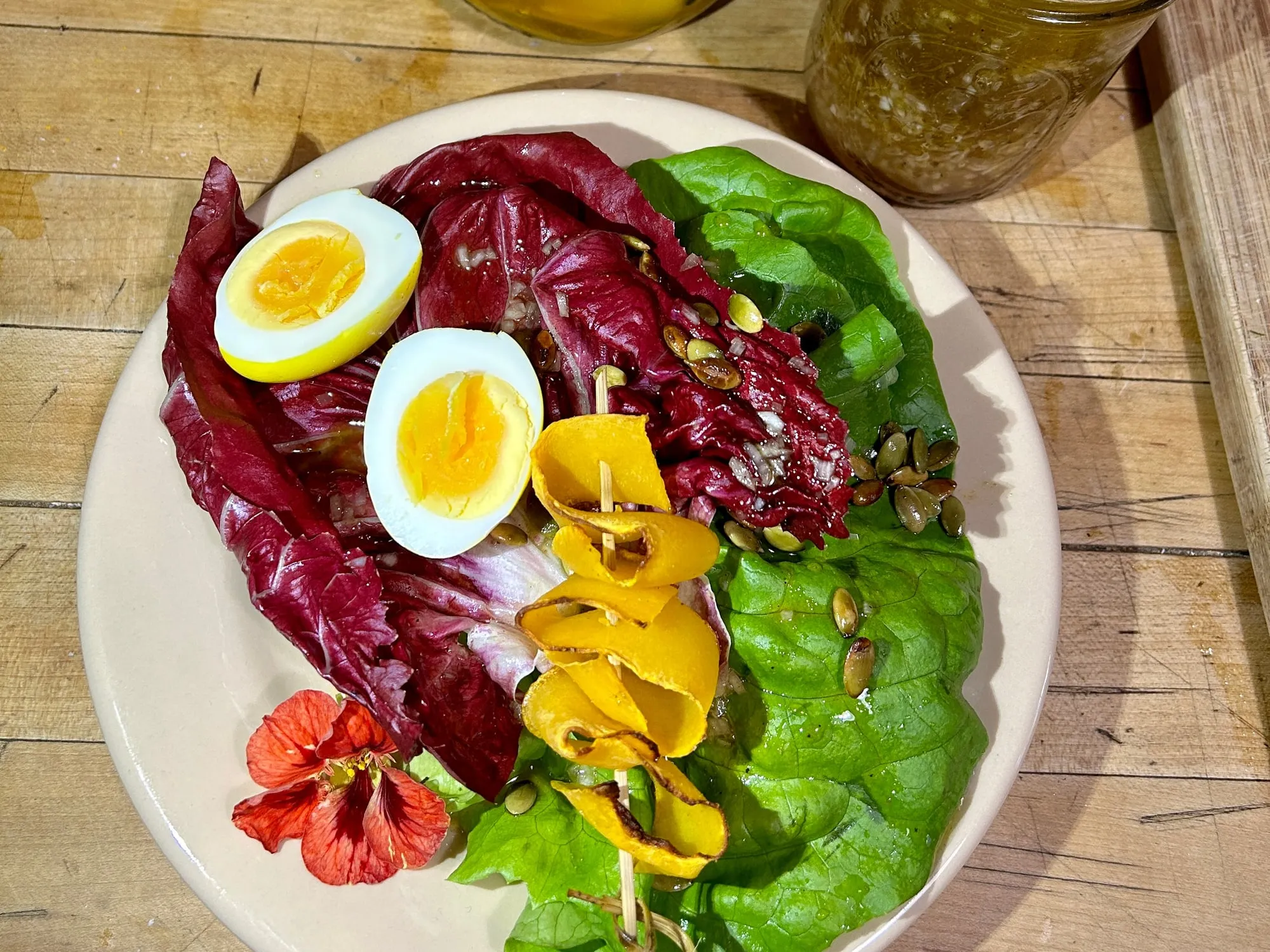 A plate of radicchio, butter lettuce, soft eggs and nasturtium flowers from the Community Supported Garden