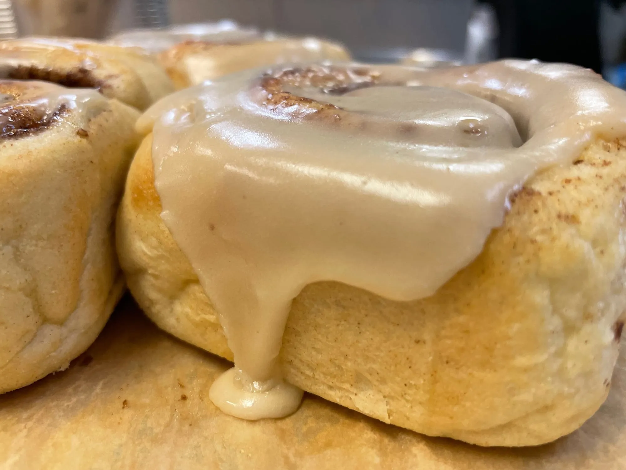 Fluffy cinnamon rolls with thick vanilla icing dripping down the sides