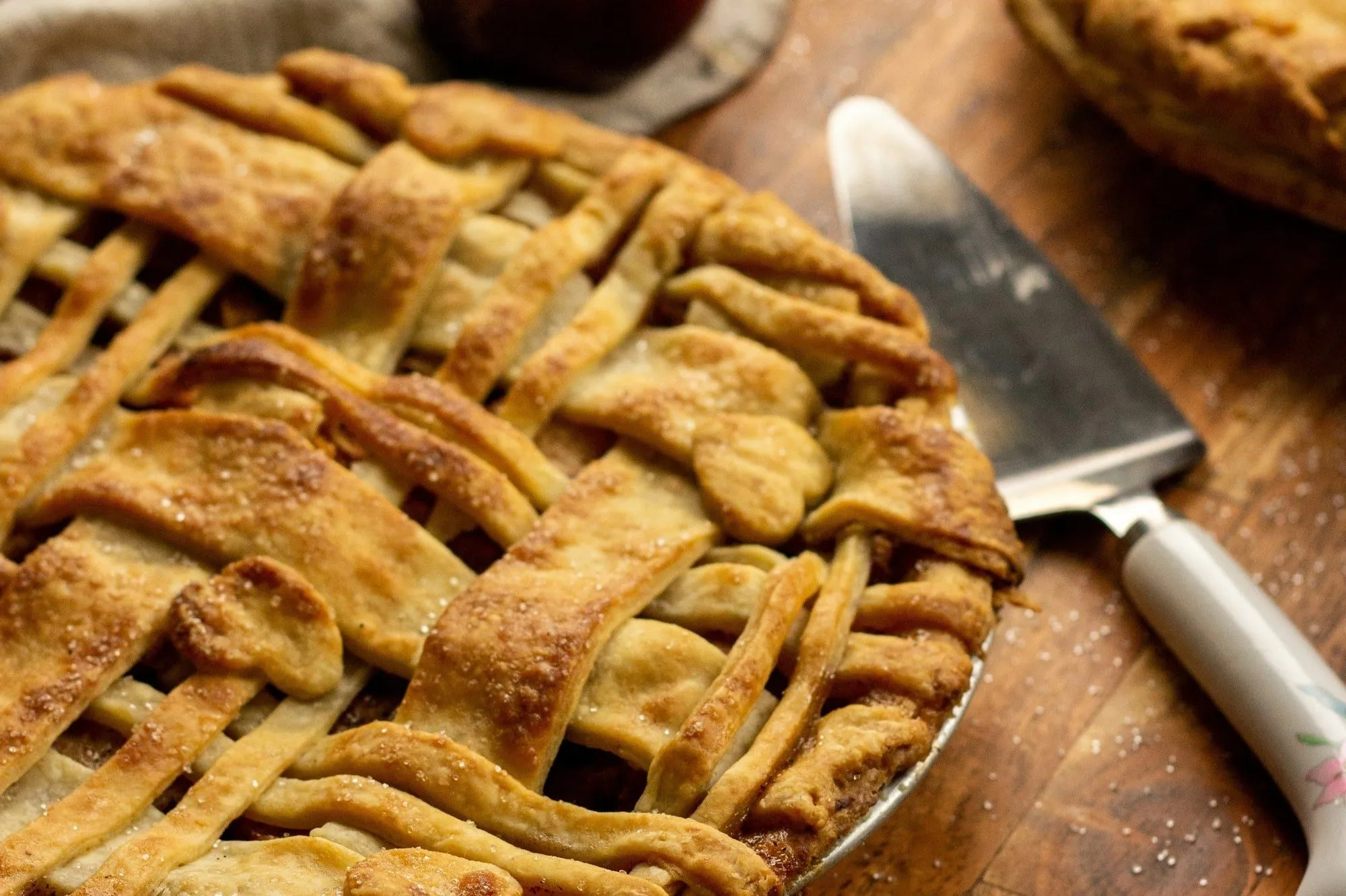 Close-up of a golden lattice-top apple pie with a pie server (stock photo)