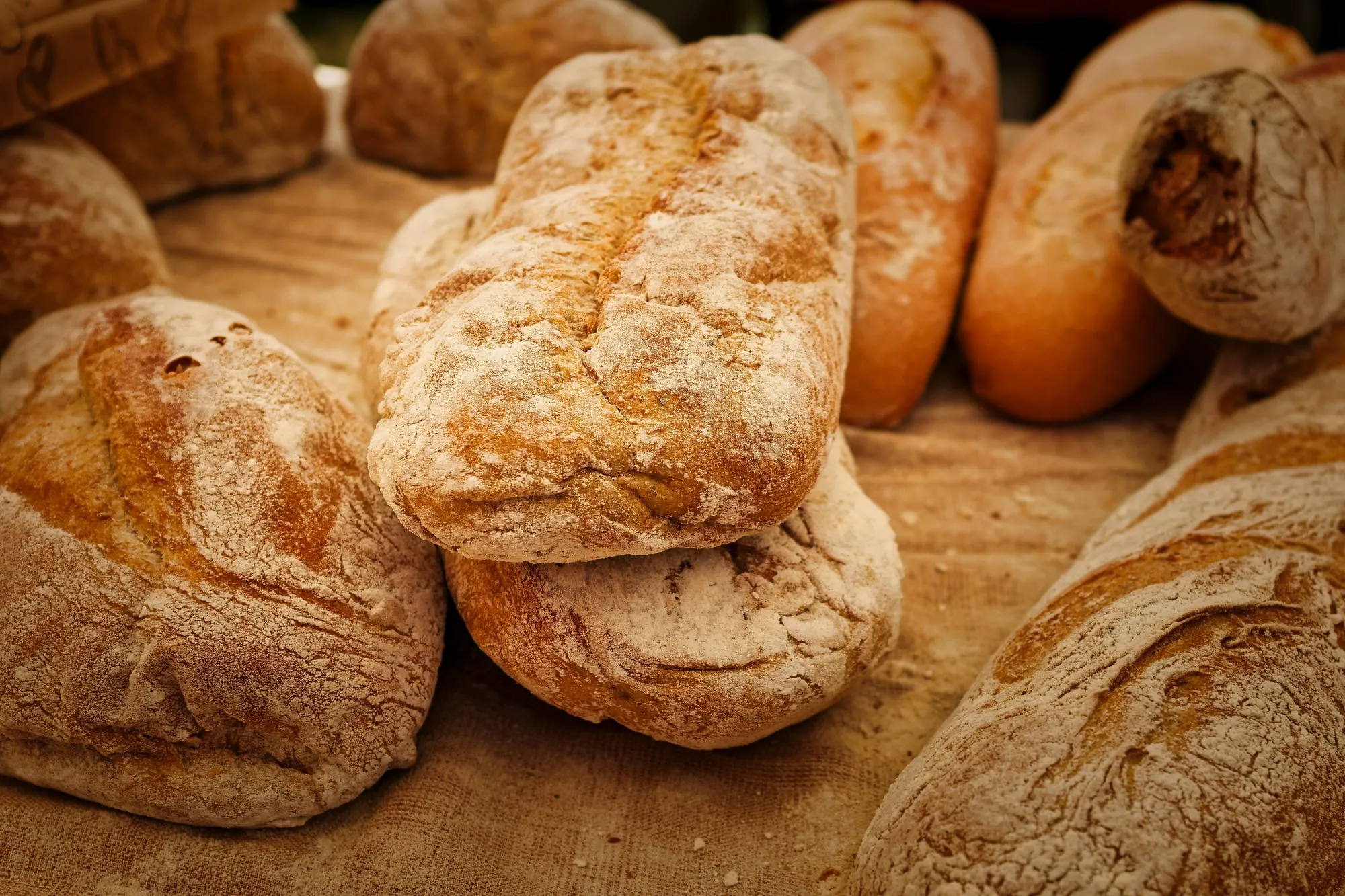 Rustic crusty artisan bread loaves on a table (stock photo)