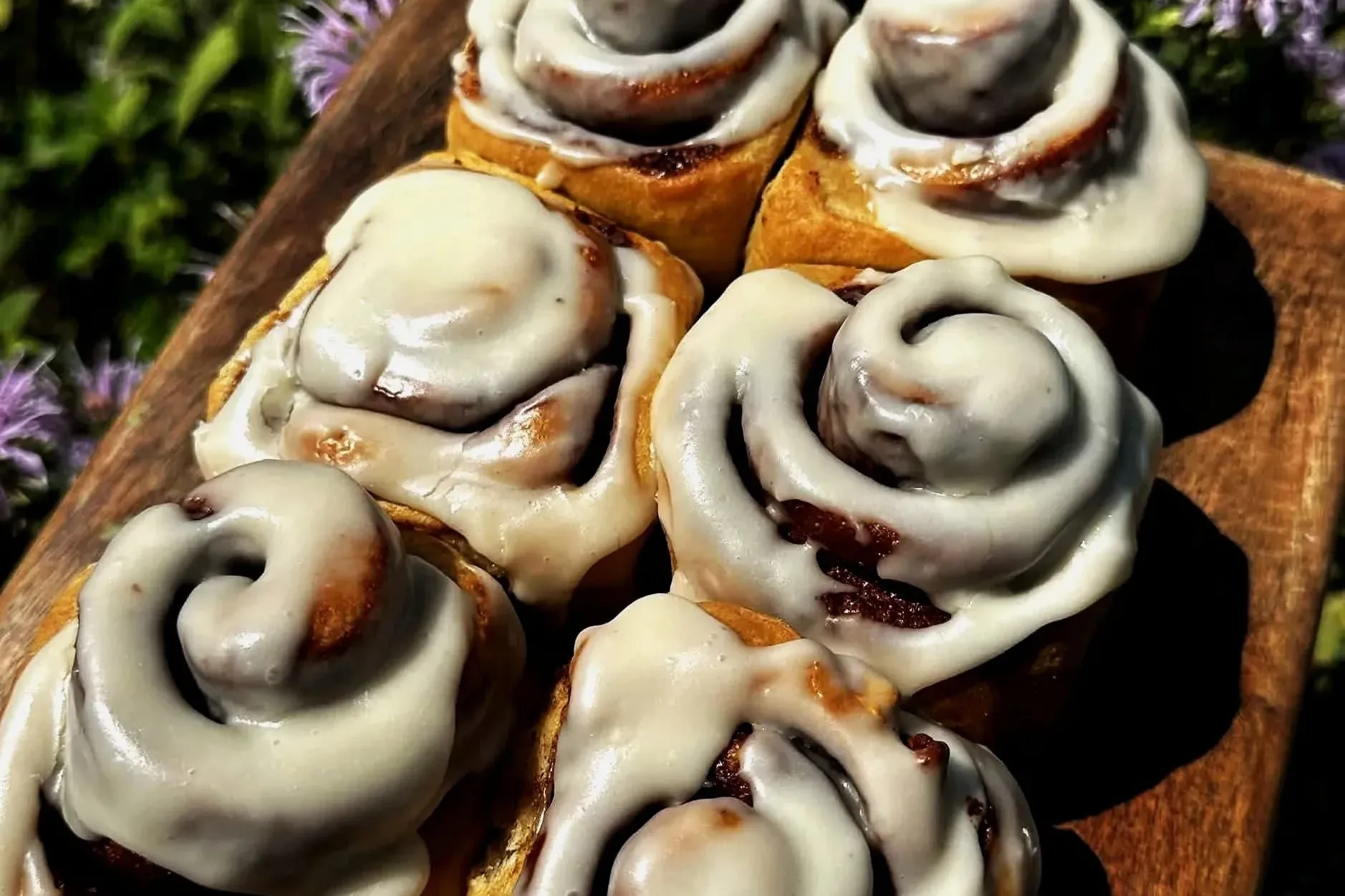 Iced cinnamon buns on a wooden board