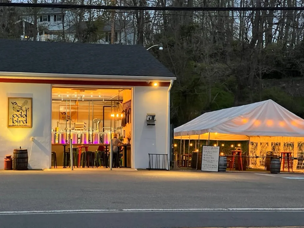 Odd Bird Brewing’s taproom and tent glowing at dusk in Stockton