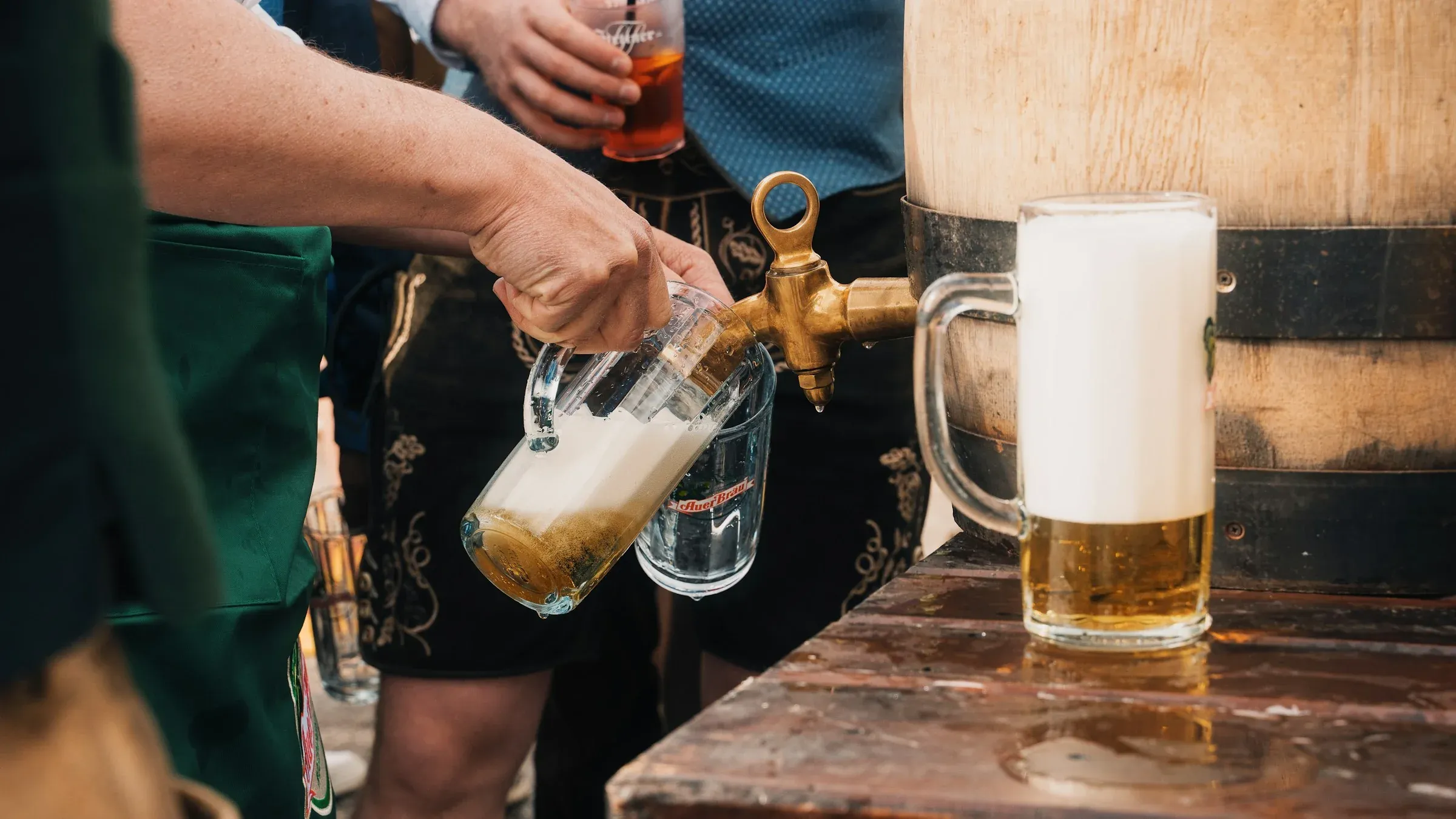 Beer poured from a wooden barrel into a glass stein
