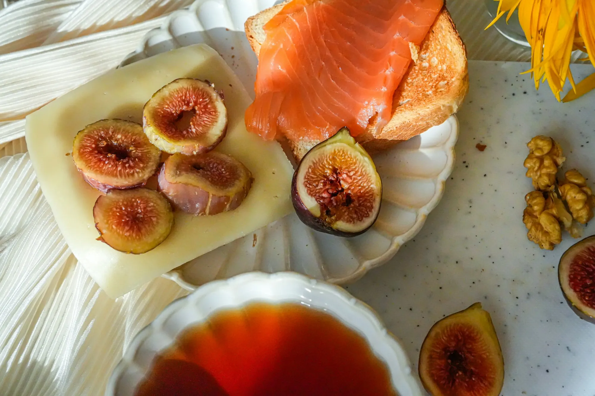 Smoked salmon on toast with sliced cheese, fresh figs and walnuts (stock photo)