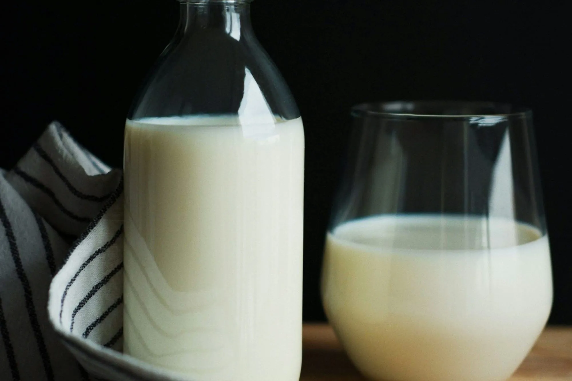 Glass bottle and glass of fresh whole milk (stock photo)