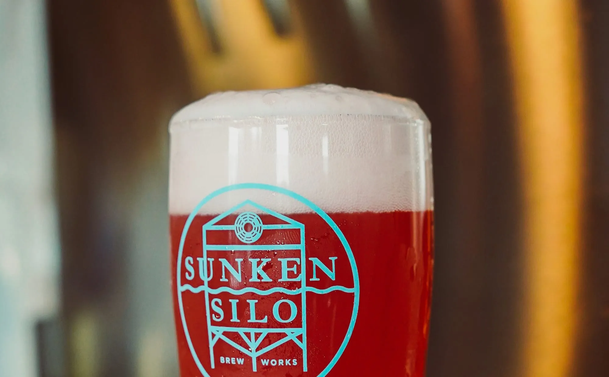 A glass of red ale with the Sunken Silo logo